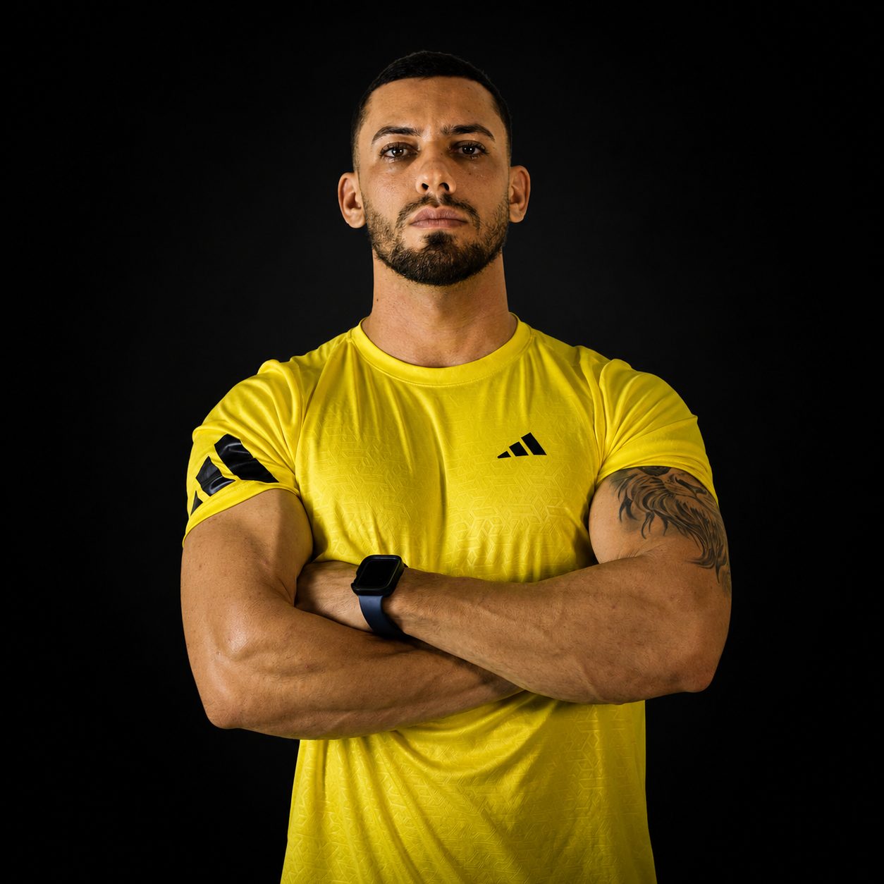 Luiz Severo, personal trainer, de camisa amarela e braços cruzados